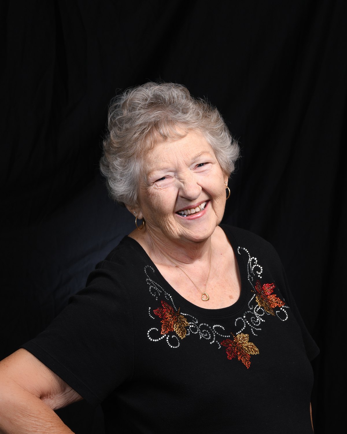 Portrait of a woman mid-laugh, turned slightly away from the camera
